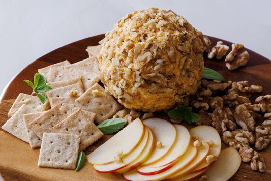 Cheeseball covered with chopped walnuts served with crackers and apples.
