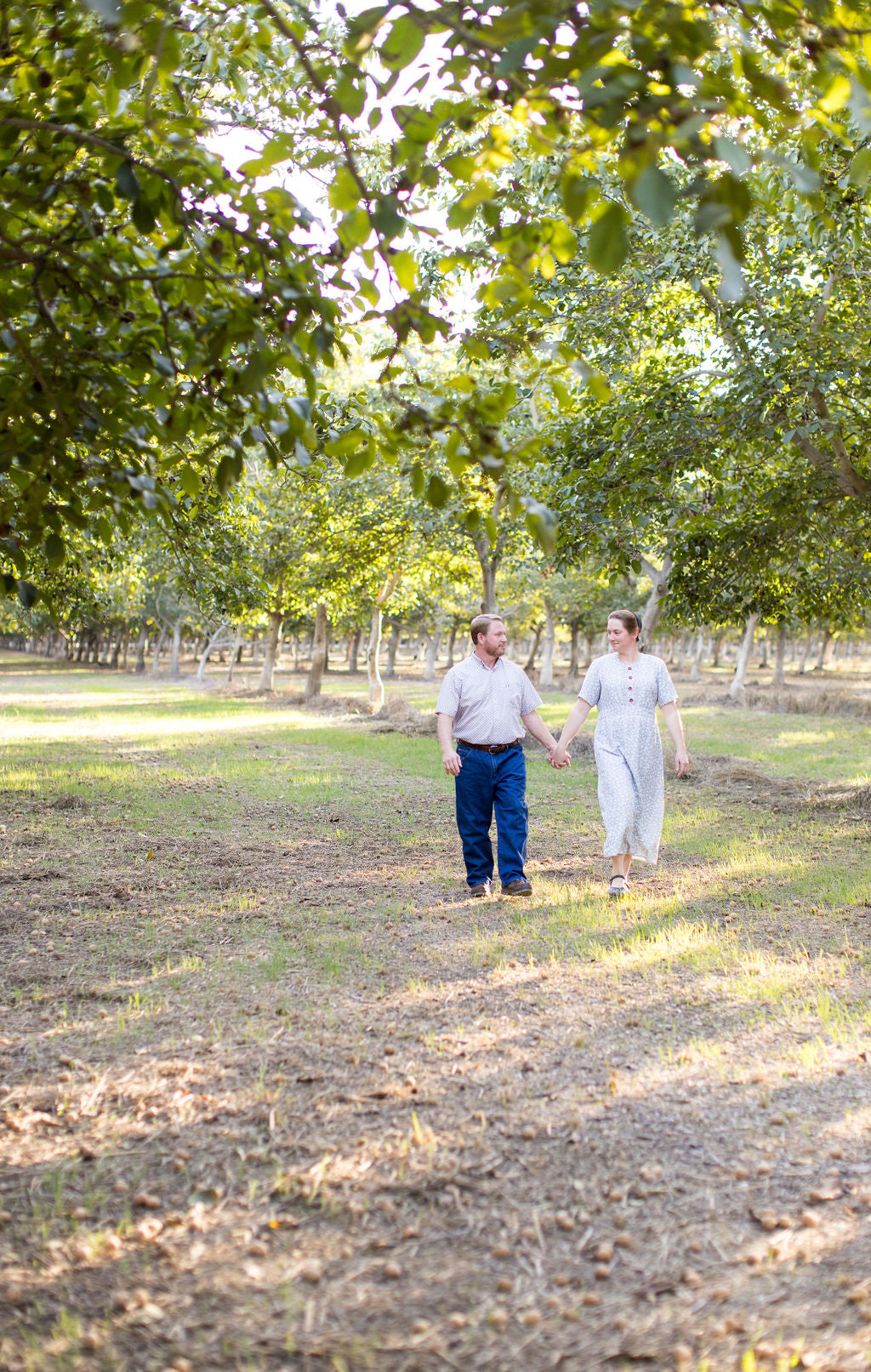 Owners Rachelle and Daniel Unruh walking in their regenerative walnut orchard.