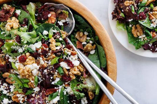 Bowl of salad with walnuts, feta cheese and craisins.
