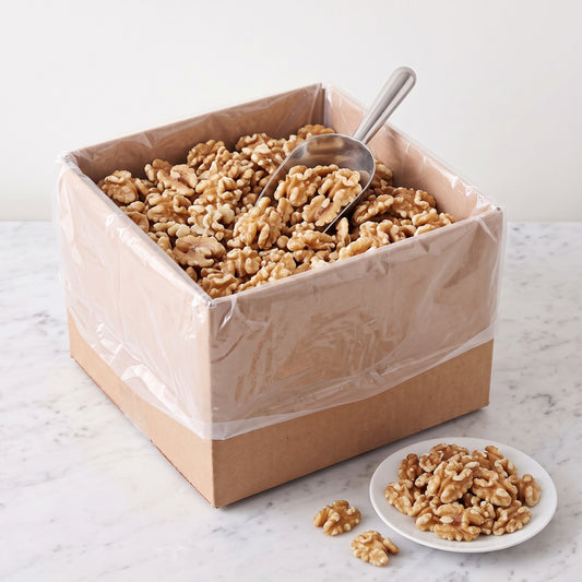 Raw Chandler walnut halves, 5 pound bulk box, with a scoop and a plate of walnuts