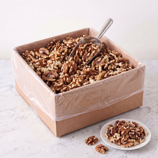 Raw Forde walnut halves, 12 pound bulk box, with a scoop and a plate of walnuts