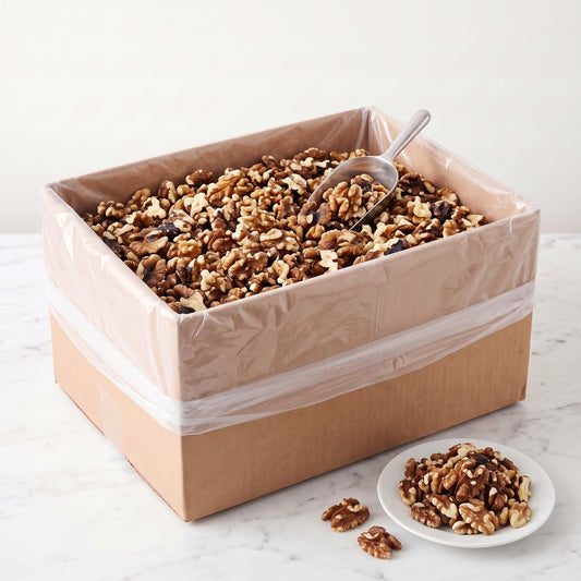 Raw Forde walnut halves, 25 pound bulk box, with a scoop and a plate of walnuts