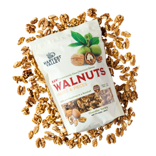 One pound bag of fresh Chandler walnuts displayed on shelled walnuts from Harvest Valley.